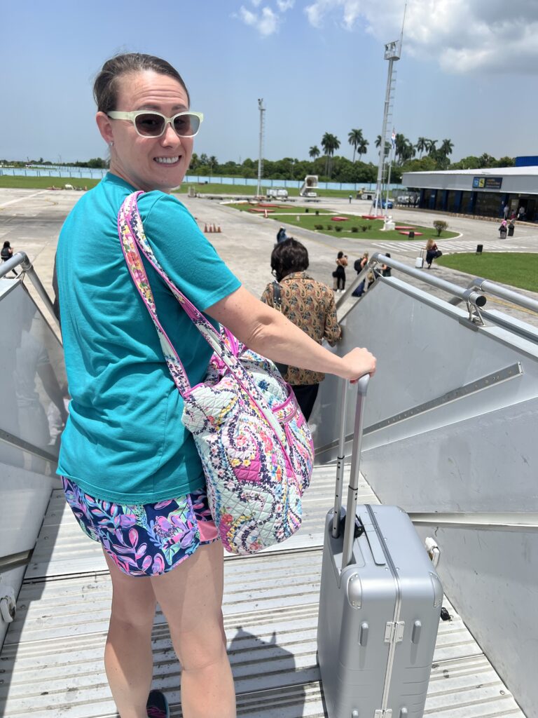 In this picture Blogging Brandi wearing Zenni Optical Sunglasses & Lilly Pulitzer Shorts. Carry-On Luggage by Monos Travel &  Vera Bradley Bag